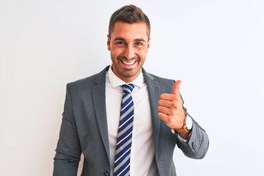 Takım elbiseli ve kravatlı genç bir iş adamı mutlu bir el hareketi yapıyor. Kameraya bakıp başarıyı gösteren ifade onaylanıyor.