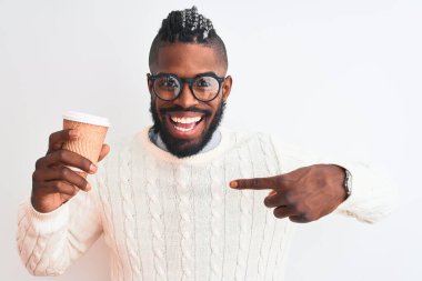 Örgü örüp kahve içen Afro-Amerikalı bir adam izole edilmiş beyaz arka planda kahveyi alıp kendini gösteren sürpriz bir yüz ifadesiyle...