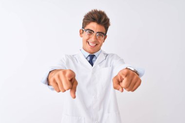 Gözlüklü ve ceketli genç yakışıklı bilim adamı izole edilmiş beyaz arka planda seni ve kamerayı işaret ediyor, pozitif ve neşeli gülümsüyor.