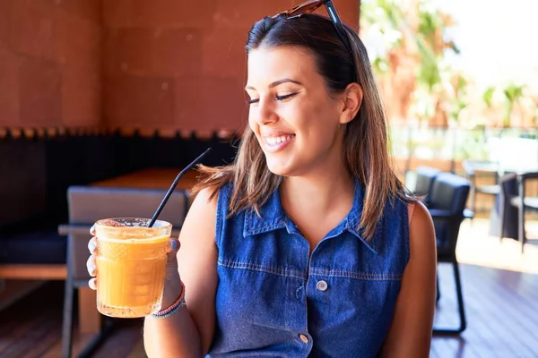 若い美しい女性が夏休みを楽しんでレストランに座って健康的なスムージーを飲む — ストック写真