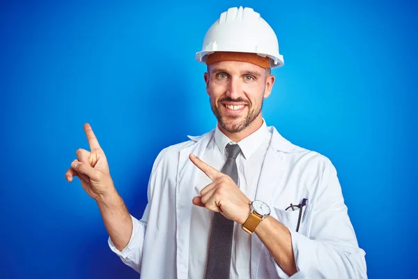 Joven Ingeniero Guapo Con Casco Seguridad Sobre Fondo Azul Aislado — Foto de Stock