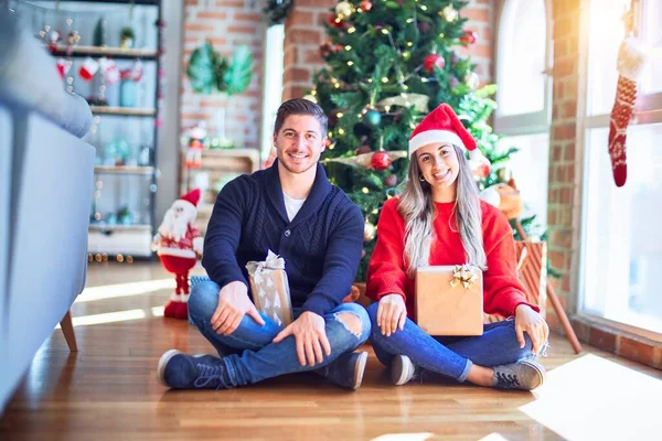 Casal Jovem Vestindo Chapéu Papai Noel Sentado Chão Torno Árvore — Fotografia de Stock