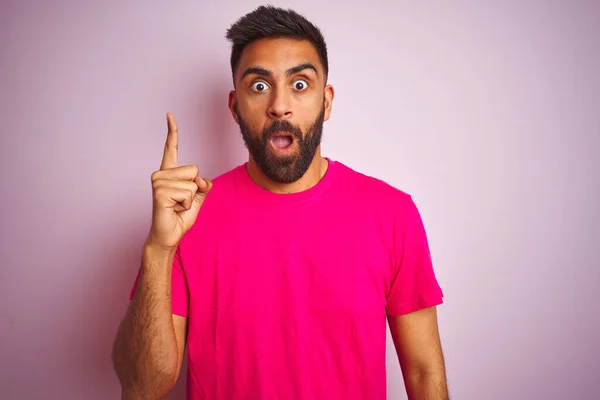 年轻的印度男人穿着T恤 站在孤立的粉色背景上 指指点点 想出了个好主意 又兴奋又快乐 第一部分 — 图库照片