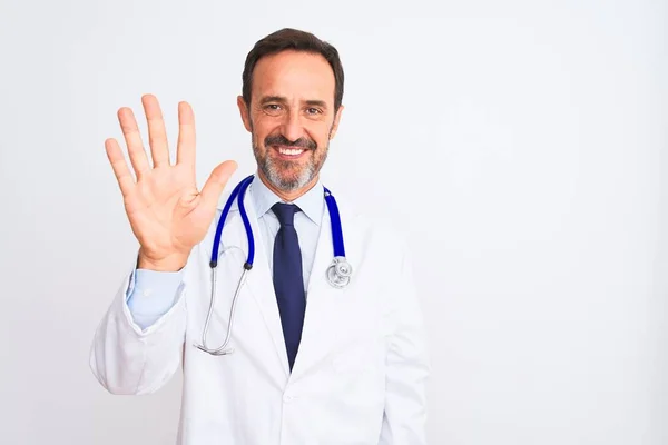 中年男人 身穿外套和听诊器 站在孤独的白色背景上 带着五号手指指尖 面带微笑 自信而快乐 — 图库照片