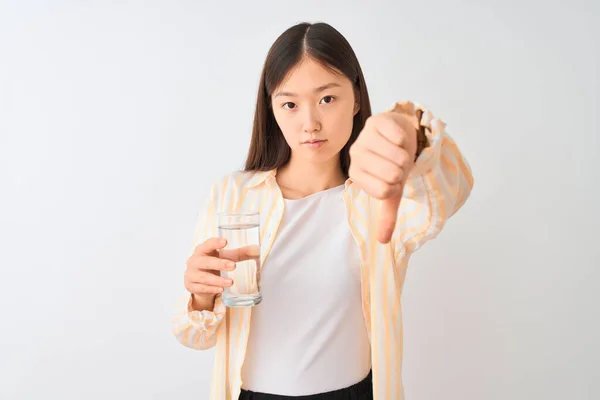 年轻的中国女性 戴着眼镜 在与世隔绝的白色背景上喝着杯水 满脸怒容 脸上带着厌恶的表情 厌恶的感觉 — 图库照片