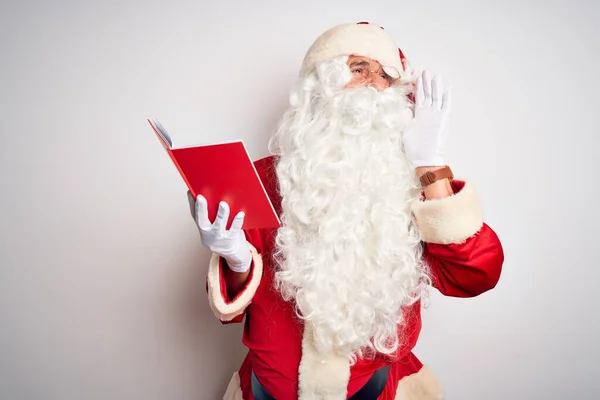 中年男人穿着圣诞老人的服装 一边在孤立的白色背景下一边看书一边大声喊着 一边手拉手地大叫着 传播概念 — 图库照片