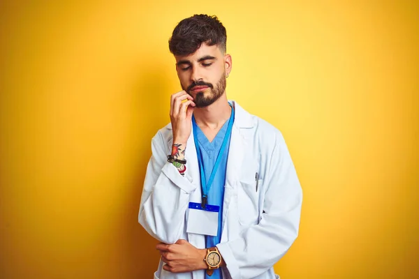 Junger Arzt Mit Tätowierung Ausweis Vor Isoliertem Gelben Hintergrund Stehend — Stockfoto