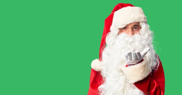 中年男子 穿着圣诞老人的服装 留着胡子 站在那里看着摄像机 用手在空中吹一个吻是可爱而性感的 爱的表达 — 图库照片