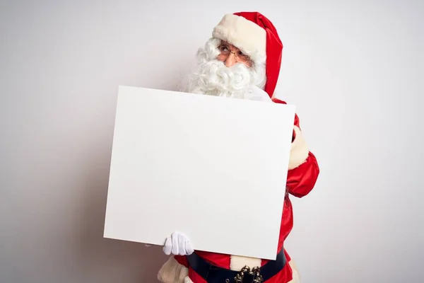 中年男子身穿圣诞老人服装 举着横幅遮掩在孤独的白色背景上 严肃地思考着问题 非常混乱的想法 — 图库照片