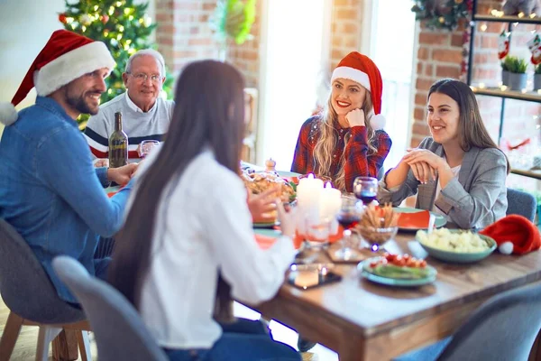 サンタの帽子をかぶっている美しい家族は笑顔で自信を持っています 自宅でクリスマスを祝うロースト七面鳥を食べる — ストック写真