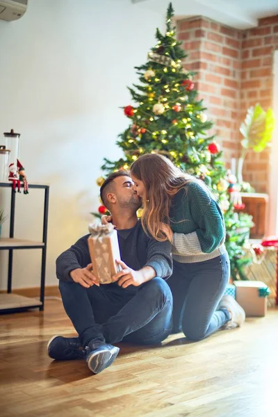 年轻漂亮的夫妇面带微笑 既快乐又自信 女人给家里的圣诞树下的男人一个惊喜 — 图库照片