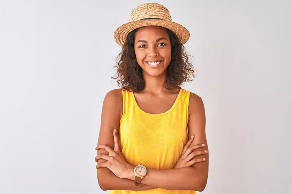 黄色のTシャツと夏の帽子を身に着けている若いブラジル人女性は カメラを見て交差腕で笑顔で孤立した白い背景幸せな顔をしています 正の人 — ストック写真