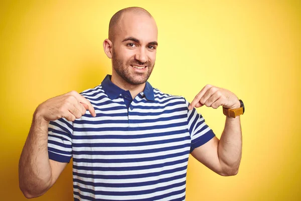 年轻的秃头男子 留着胡须 穿着休闲的条纹蓝色T恤 披着黄色孤立的背景 面带微笑 带着自信 用手指指着自己 自豪而快乐 — 图库照片