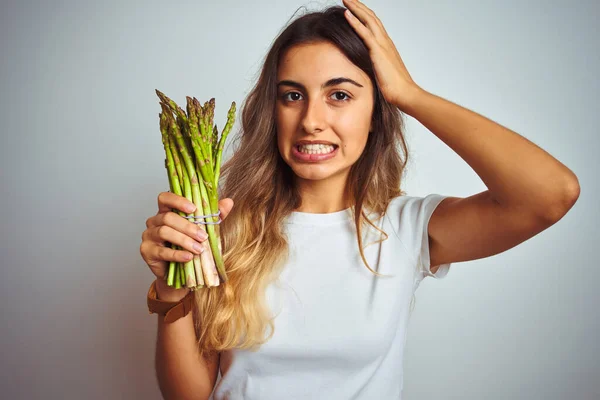 Jovem Mulher Bonita Comer Espargos Sobre Fundo Isolado Cinza Estressado — Fotografia de Stock