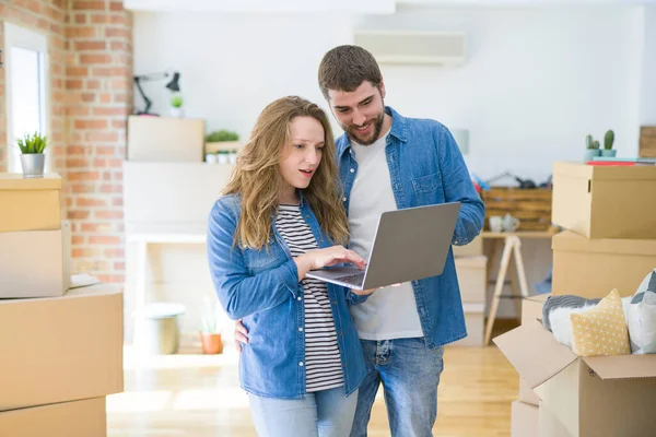 Young couple using computer laptop standing on a room around car