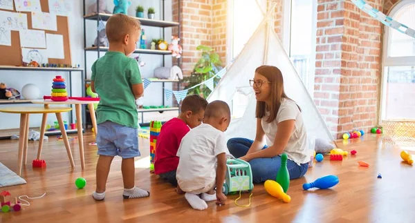 Junge Schöne Lehrerin Und Kleinkinder Spielen Kindergarten Mit Viel Spielzeug — Stockfoto