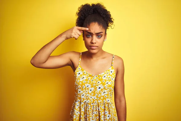 Африканская Американка Обычном Цветочном Платье Стоящем Изолированном Жёлтом Фоне Указывая — стоковое фото