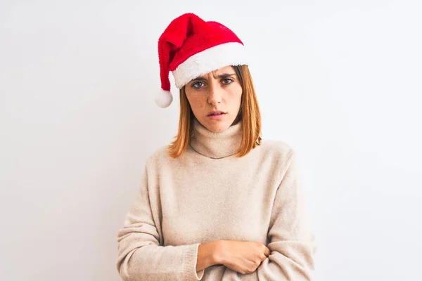 孤立した背景懐疑的で神経質な上にクリスマスの帽子をかぶって美しい赤毛の女性は 両腕を組んで顔に不承認の表現 負の人 — ストック写真
