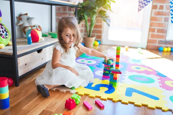 Sevimli Sarışın Çocuk Kreşteki Oyuncakların Etrafında Yapı Taşlarıyla Oynuyor — Stok fotoğraf