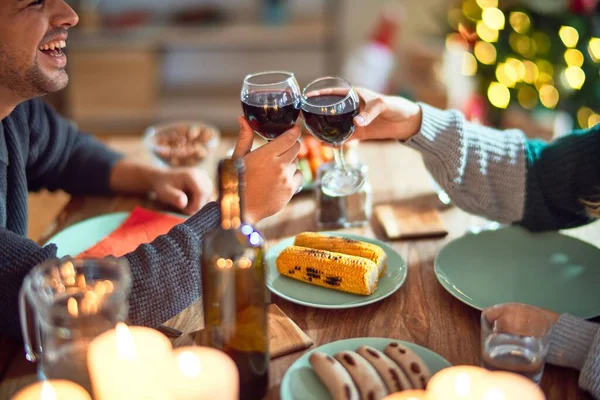 若い美しいカップルの幸せと自信を笑顔 家庭でクリスマスを祝うワインで食べ物やトーストを食べる — ストック写真