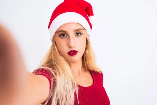 女性身に着けているクリスマスサンタ帽子作ります自画撮りカメラによって隔離された白い背景とともに自信を持って表現上のスマートフェイス思考深刻な — ストック写真