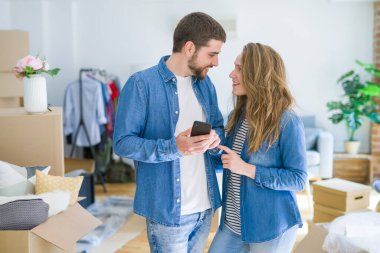 Genç çift cardb etrafında akıllı telefon kullanarak yeni bir eve hareket