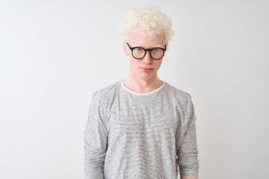 Genç albino sarışın adam çizgili tişört ve gözlüklerle izole edilmiş beyaz arka planda depresif ve üzüntülü, sinirli ve korkmuş bir şekilde ağlıyor. Üzücü ifade.