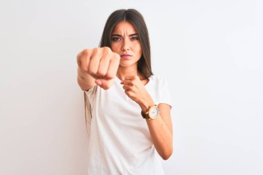 Gündelik tişört giyen genç güzel bir kadın izole edilmiş beyaz arka planda duruyor. Yumruk yumruğa dövüşmek, agresif ve öfkeli saldırı, tehdit ve şiddet.