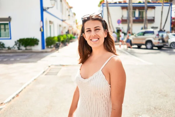 Young beautiful woman at the colorful village of Puerto de Mogan, smiling happy at the street on summer holidays