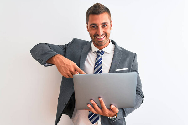 Young handsome business man working using computer laptop over isolated background very happy pointing with hand and finger