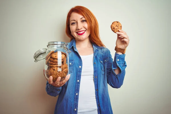 Joven Mujer Pelirroja Hermosa Sosteniendo Tarro Galletas Sobre Fondo Blanco — Foto de Stock