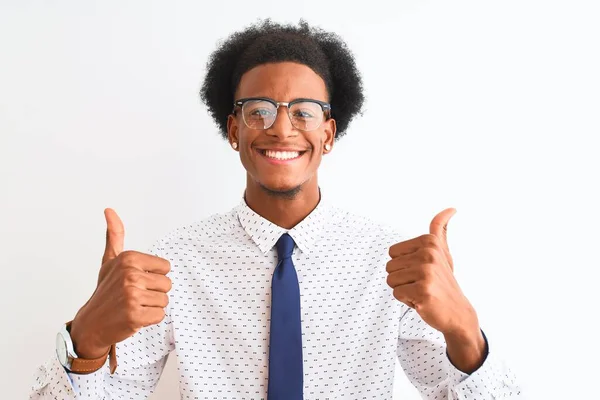 若いアフリカ系アメリカ人のビジネスマンは 手で積極的なジェスチャーを行う孤立した白い背景の成功のサインの上にネクタイと眼鏡を着用し 親指を笑顔と幸せ 陽気な表情と勝者のジェスチャー — ストック写真