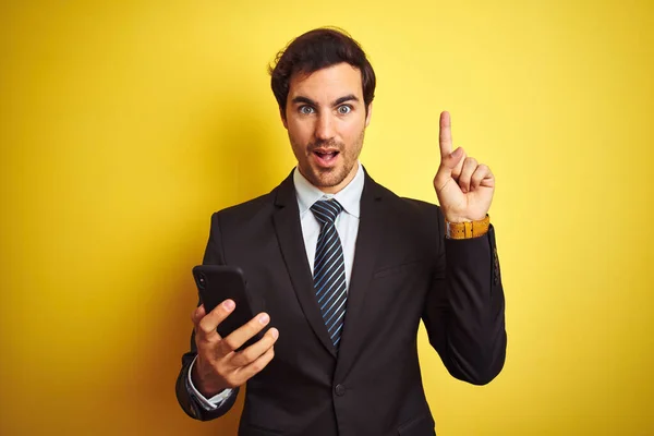 Mladý Pohledný Podnikatel Používající Chytrý Telefon Stojící Nad Izolovaným Žlutým — Stock fotografie