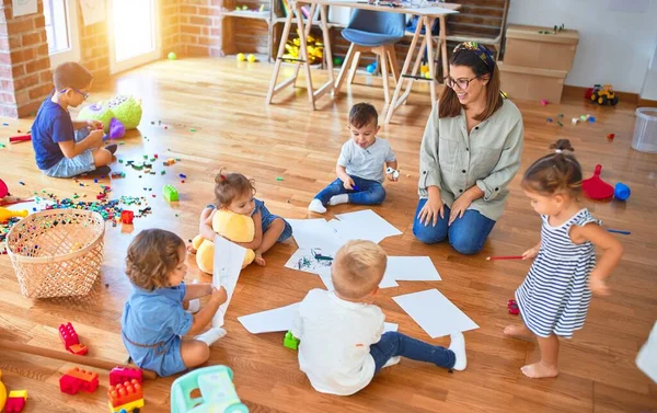 Vacker Lärare Och Grupp Småbarn Sitter Golvet Ritning Med Papper — Stockfoto