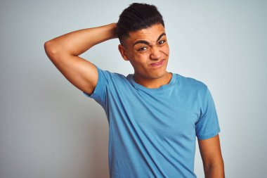 Mavi tişört giyen genç Brezilyalı adam izole edilmiş beyaz arka planda duruyor. Soruyu merak ediyor. Şüpheyle kararsız, kafa kafaya düşünerek. Düşünceli kavram.