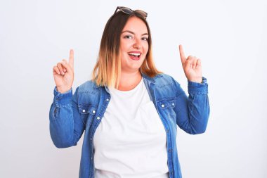 İzole edilmiş beyaz arka plan üzerinde duran güzel bir kadın. Şaşırmış, şaşırmış, parmaklarıyla işaret ediyor ve kollarını kaldırıyordu..