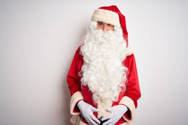 Noel Baba kostümü giymiş orta yaşlı yakışıklı bir adam soyutlanmış beyaz arka planda duruyor. Depresyonda ve endişe içinde, sinirli ve korkmuş bir halde. Üzücü ifade.