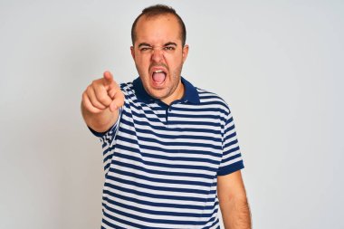 Sıradan çizgili polo giyen genç adam izole edilmiş beyaz arka planda dikiliyor. Kameraya kızgın ve sinirli olduğunu gösteriyor.