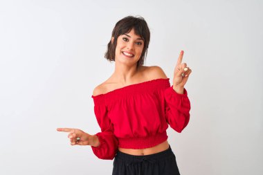 Kırmızı yaz tişörtü giyen genç ve güzel bir kadın izole edilmiş beyaz arka planda duruyor. Kendine güvenen, farklı yönleri gösteren bir gülümseme. Reklam için boşluk kopyala