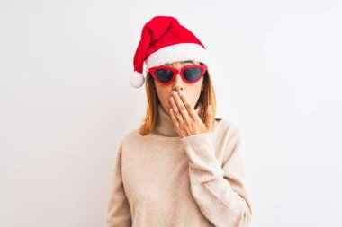 Güzel kızıl saçlı kadın, Noel şapkası takıyor ve kırmızı güneş gözlüğü takıyor. Ağzı kapalı. Yanlışlıkla şok olmuş, korku ifadesi, sessizlikten korkmak, gizli bir kavram.