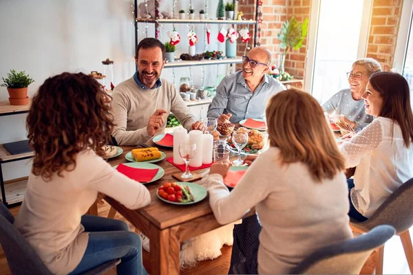 Family and friends dining at home celebrating christmas eve with traditional food and decoration, celebration of festive winter time