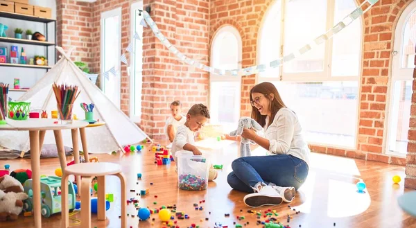 Hermosa Maestra Niños Pequeños Jugando Alrededor Montón Juguetes Jardín Infantes — Foto de Stock