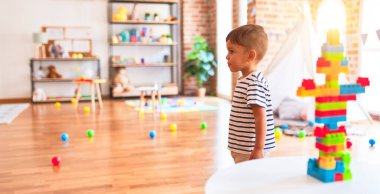 Güzel çocuk anaokulunda inşaat bloklarıyla oynuyor.