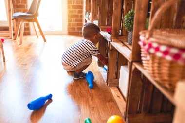 Anaokulunda bir sürü oyuncakla bekleyen güzel bir çocuk.