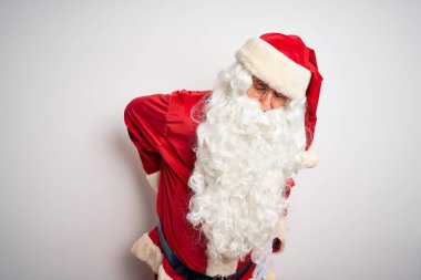 Orta yaşlı, yakışıklı, Noel Baba kostümü giyen, izole edilmiş beyaz arka planda duran, sırt ağrısı çeken, elle dokunan, kas ağrısı çeken bir adam.