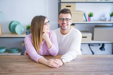 Genç güzel çift evde masada oturan, sarılma 