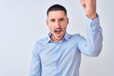 Genç ve yakışıklı bir iş adamı öfkeli ve öfkeli bir şekilde öfkeli bir şekilde arka planda duruyor ve öfkeyle bağırıyor. Öfke ve agresif kavram.