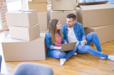 Genç çift c kullanarak karton kutular etrafında katta oturan