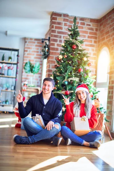 Casal Jovem Vestindo Chapéu Papai Noel Sentado Chão Torno Árvore — Fotografia de Stock