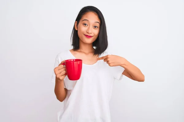 Молодая Красивая Китаянка Пьет Чашку Кофе Изолированном Белом Фоне Удивленным — стоковое фото
